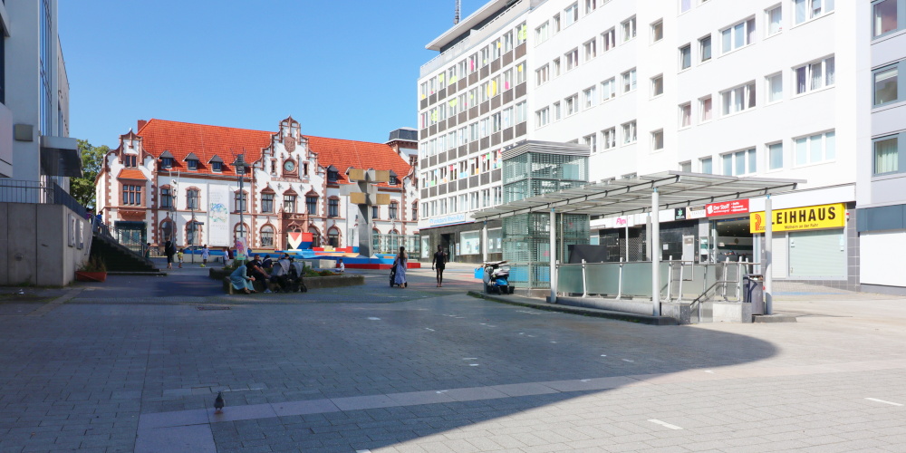Synagogenplatz in Mülheim, rechts eine Hochhauszeile, hinten ein historisches Gebäude, die Alte Post