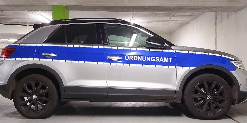 Ein silberfarbener Pkw mit blauem Streifen und der Aufschrift "Ordnungsamt" von der Seite